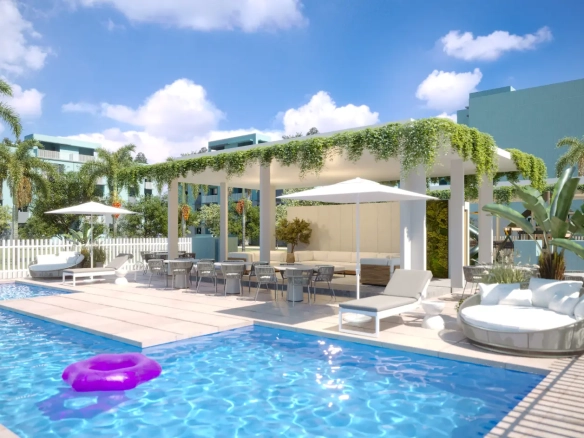 The resort-style pool club at Mallorca Village in La Romana, with a large swimming pool, sun loungers, and tropical landscaping.