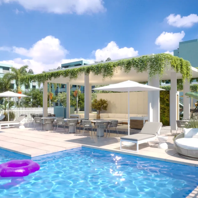 The resort-style pool club at Mallorca Village in La Romana, with a large swimming pool, sun loungers, and tropical landscaping.