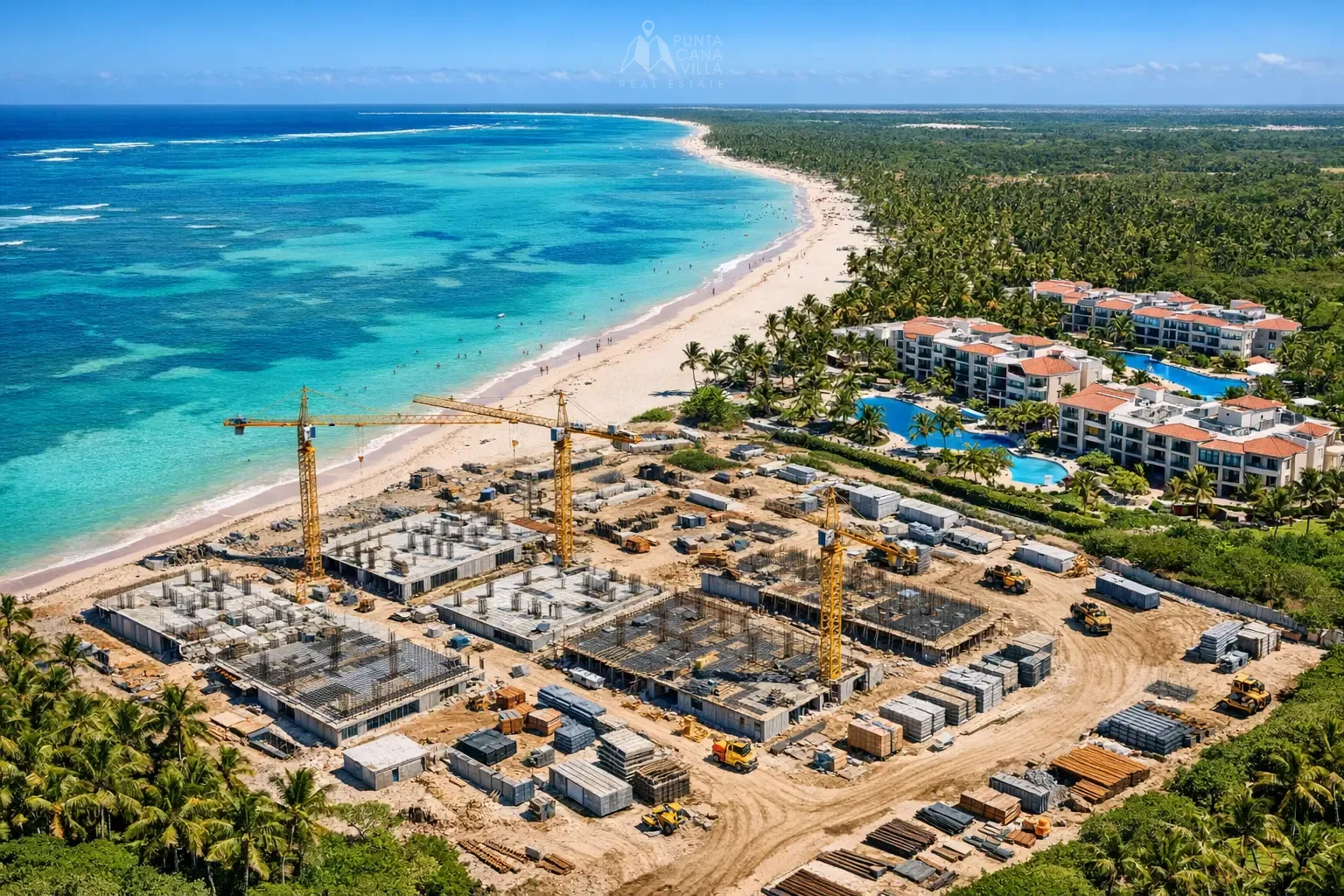 Aerial view of Punta Cana pre-construction condo development site with cranes and completed resort buildings near the Caribbean coastline